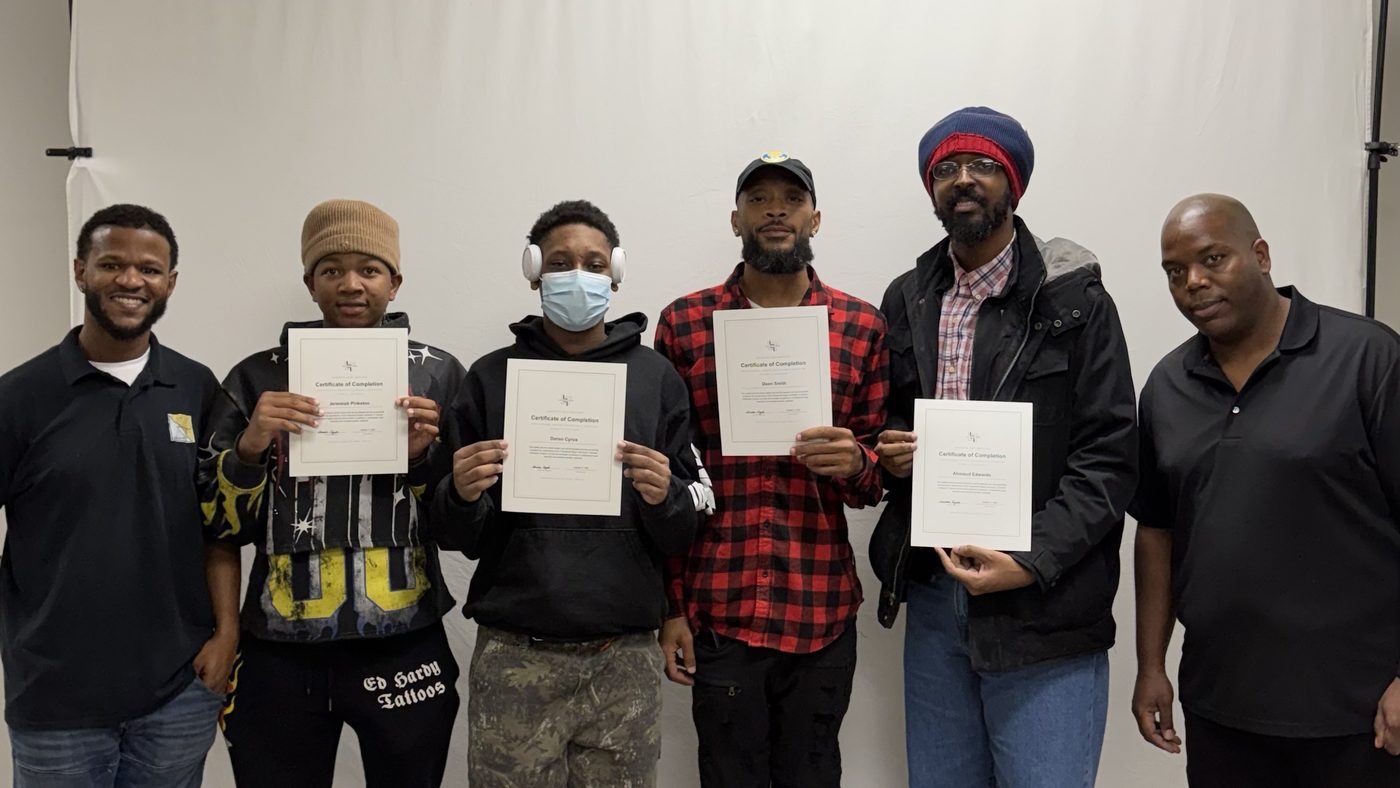 The October 2026 cohort holding their certificates of completion with the instructor and the founder